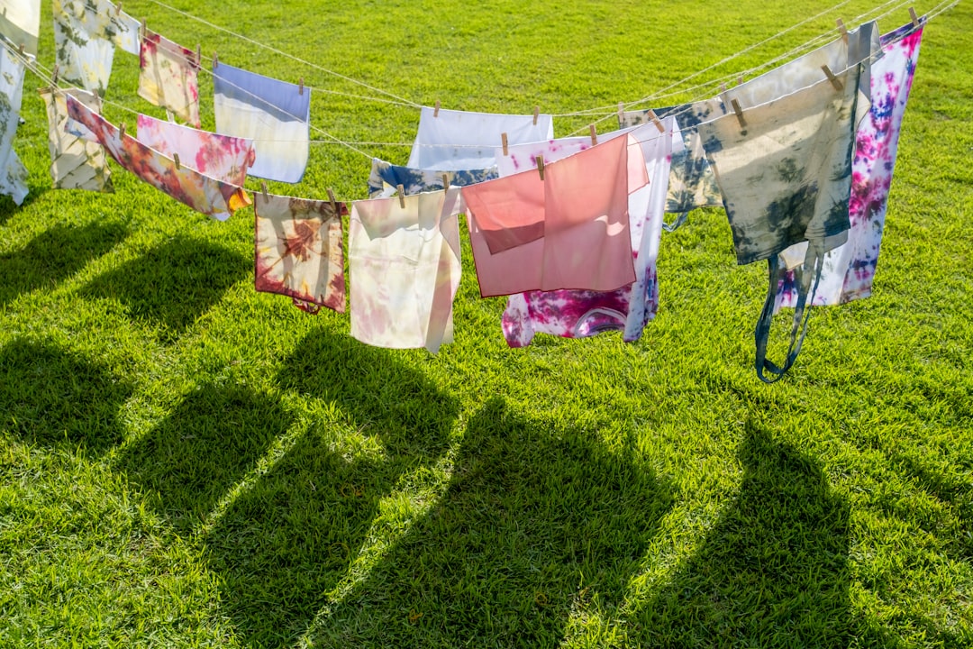 pink and white textiles hanged on brown wooden clothes hanger